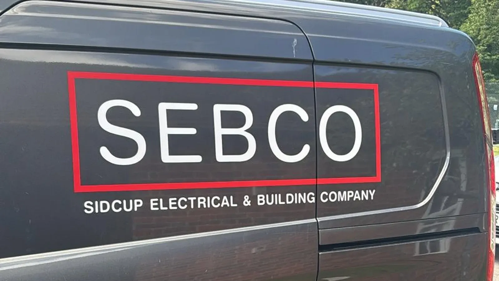 The SIDCUP ELECTRICAL van in Sidcup, black Ford Transit Connect with the red and white SEBCO Sidcup Electrical and Building Company livery
