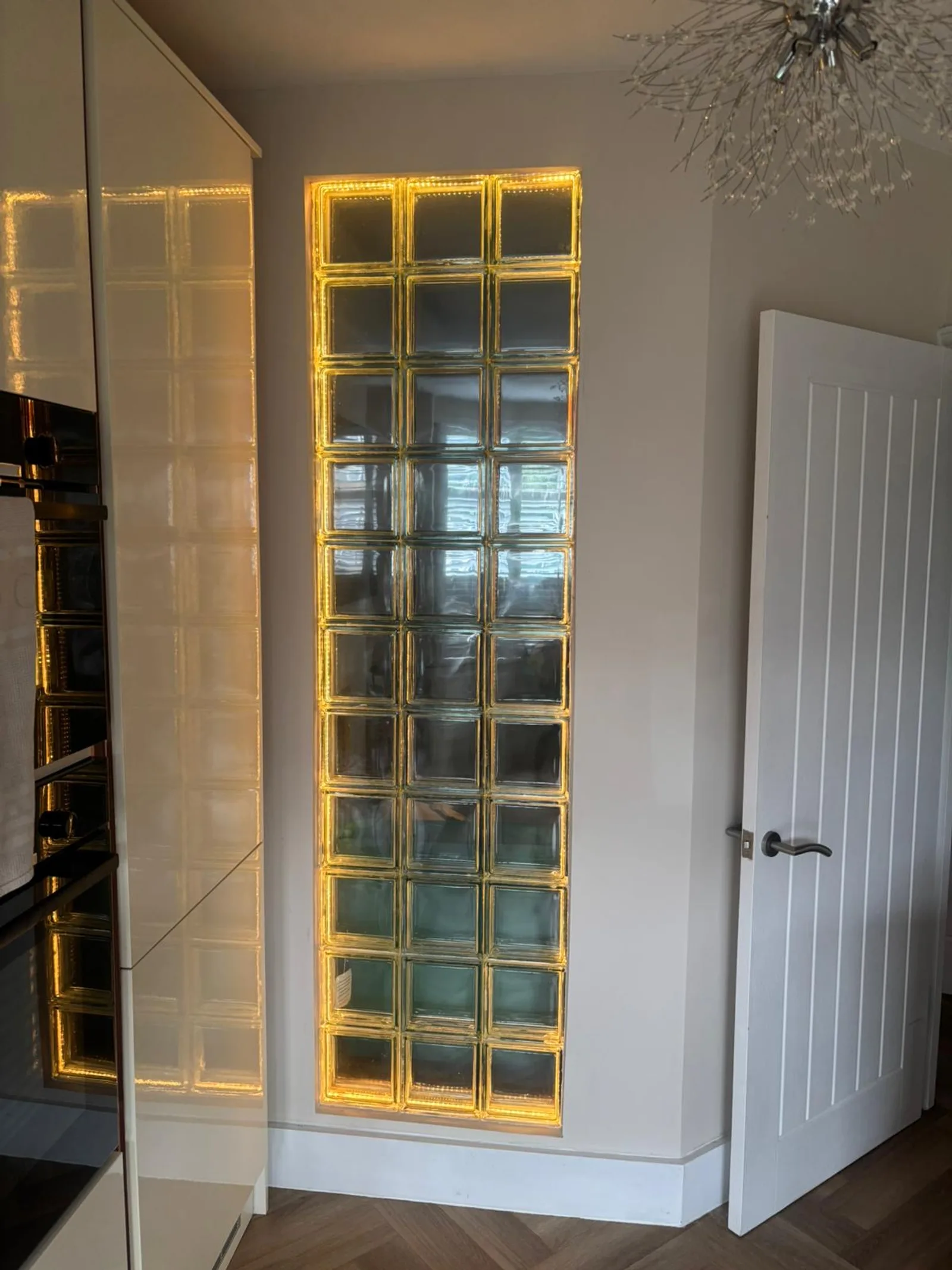 The same Sidcup Electrical glass block feature wall lit in warm amber