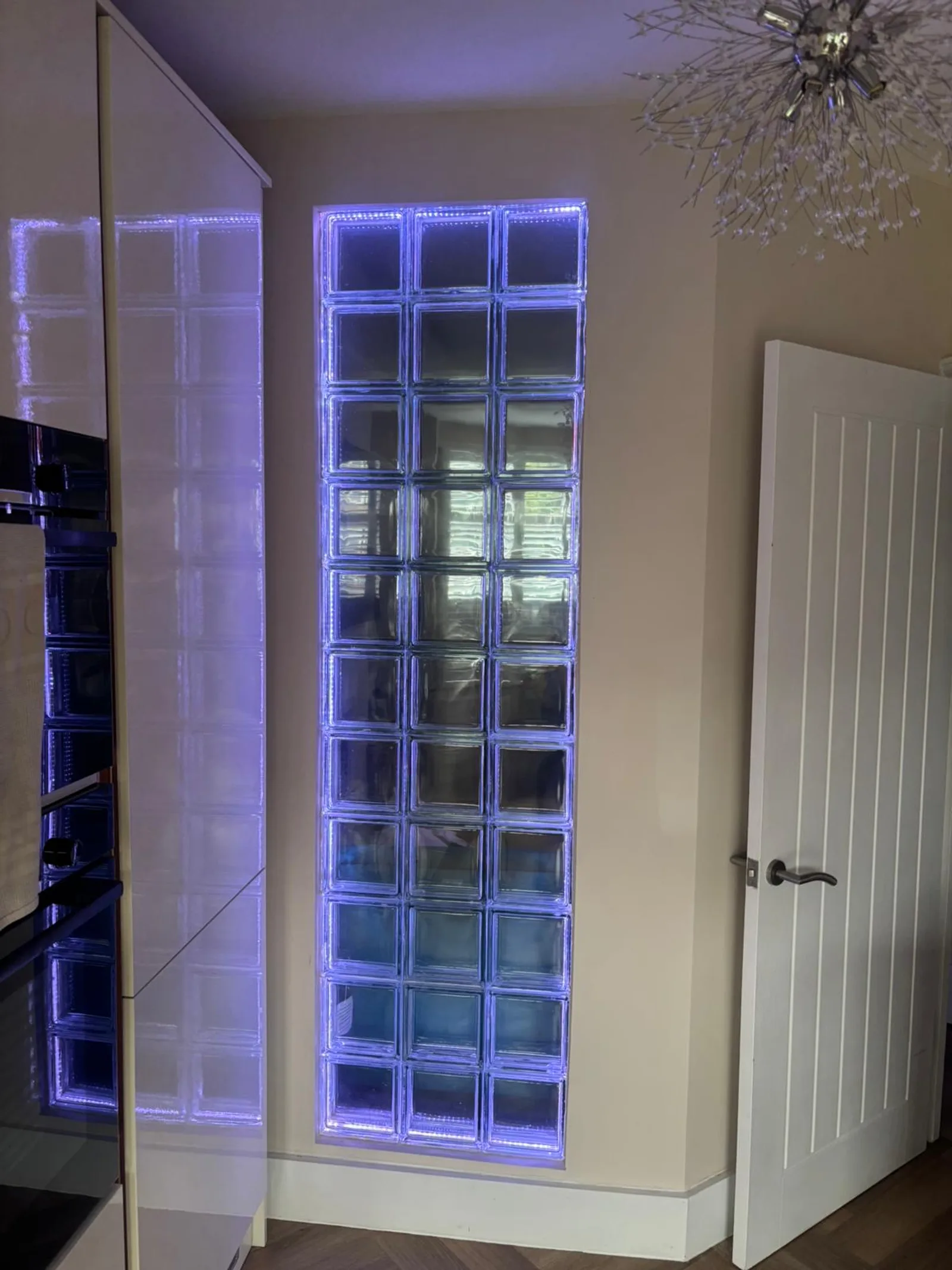 The same Sidcup Electrical glass block feature wall lit in cool blue