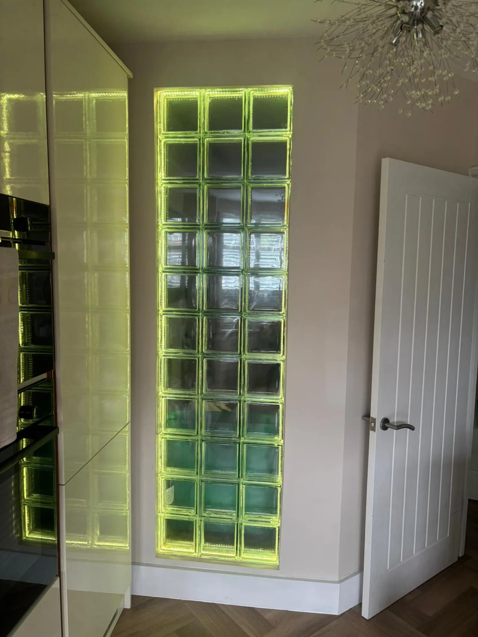 Glass block feature wall installed by Sidcup Electrical glowing green, LED colour-changing lighting in a Sidcup home